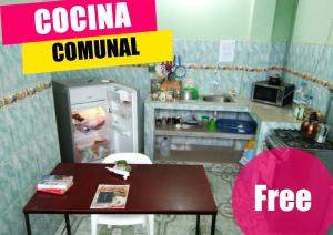 uma pequena cozinha com uma mesa e um frigorífico em Hostal Alcazaba em Puerto López
