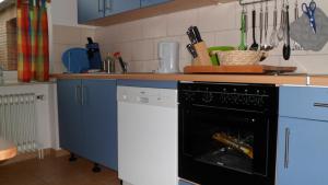 ヴェスターシュテーデにあるFerienwohnung_Beethovenstrasseのキッチン(青いキャビネット、黒い食器洗い機付)