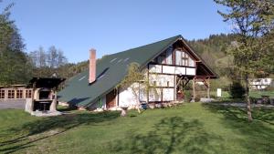 a house with a green roof on a yard at Casa Moeciu Family in Moieciu de Jos