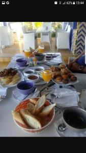 a table with plates of food and glasses of orange juice at Issablanca in Oualidia +41 photos