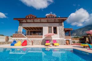 a villa with a swimming pool in front of a house at Smans Villas in Oludeniz