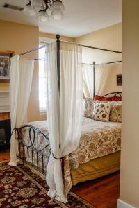a bedroom with a canopy bed with white curtains at The Swope Manor Bed & Breakfast in Gettysburg