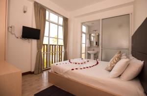 Un dormitorio con una cama grande con flores rojas. en Express Inn at Hulhumale, en Hulhumale