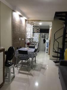a dining room with a table and chairs and a staircase at Porto de Galinhas Duplex Rocha in Porto De Galinhas