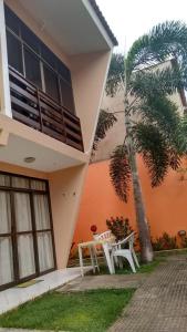 a table and a chair in front of a building at Porto de Galinhas Duplex Rocha in Porto De Galinhas