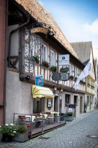 un bâtiment avec des tables et un parasol dans une rue dans l'établissement AKZENT Hotel Am Bach, à Dettelbach