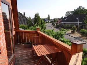 a wooden deck with a wooden table and a bench at Uferschwalbe in Kopperby