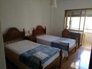 una camera con due letti e una finestra di LUCINDA`S HOUSE a Braga