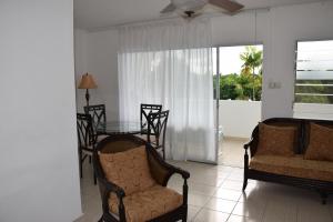 a living room with two chairs and a table and a window at 1 Bed Apartment/Condo in Saint James