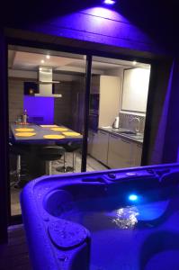 a room with a kitchen with a tub and a table at Gites Spa Strasbourg - Gite le 14 in Furdenheim
