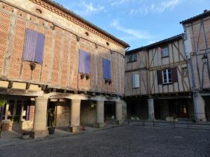 an old building with blue shuttered windows on a street at Plume Et Pinceau in Montdragon