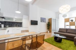 a kitchen and living room with a table and a couch at Apartment Jindrisska in Prague