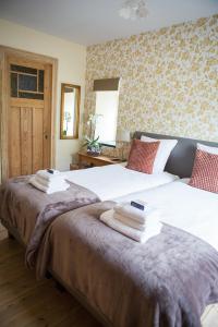 a bedroom with two beds with towels on them at B&B Pastorie van Merkem in Merkem