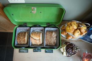 un recipiente verde con 4 bandejas de sándwiches y bollería en B&B Pastorie van Merkem en Merkem