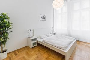 プラハにあるApartment Jindrisskaの白いベッドルーム(ベッド1台、鉢植えの植物付)