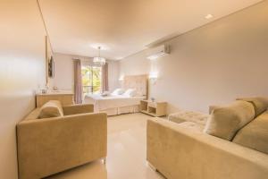 a living room with two couches and a bed at Marruá Hotel in Bonito
