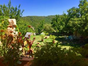 a garden with tables and chairs in the grass at El Achkar Guesthouse in Beït ed Dîne