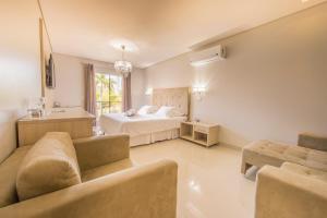 a living room with a bed and a couch at Marruá Hotel in Bonito