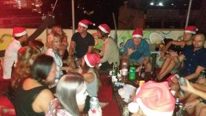 Un groupe de personnes portant des chapeaux de santa à une fête dans l'établissement Oasis Guest House, à Kuala Lumpur