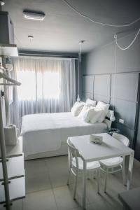 a bedroom with a white bed and a table and a table at Fuerteventura in Loft in Gran Tarajal