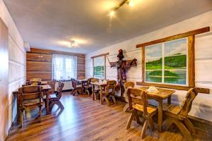 a dining room with tables and chairs and windows at Willa Diana- z panoramą jeziora i gór w Polańczyku in Polańczyk