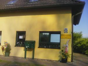 a yellow building with two windows on it at Haus Lebensart Bansin in Neu Sallenthin