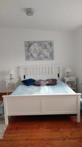 ヴィルヘルムスハーフェンにあるFewo Meerestraumの白いベッドルーム(テーブル2台付)の白いベッド1台