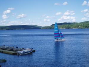 a sailboat and a boat on a large lake at Silver Springs Cottage Resort in Harcourt