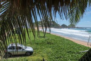 a car parked under palm trees on the beach at Cafe Maya - Casa Acalli in Zipolite