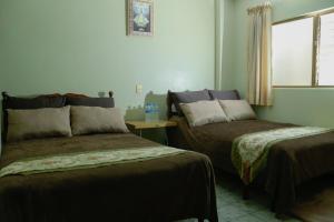 a bedroom with two beds and a window at Hotel Diana in San Juan de los Lagos