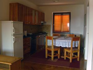 a kitchen with a table and chairs and a refrigerator at Brko Apartment in Medulin