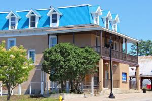 una casa grande con techo azul en una calle en Le Voyageur Inn, en Mattawa