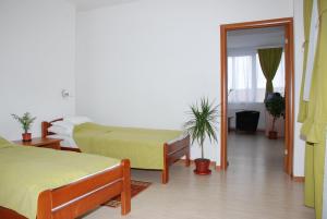 a hotel room with two beds and a hallway at M Garni Hotel in Vranje