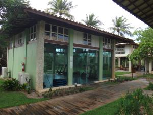 a building with large glass windows and palm trees at Reserva Imbassaí Vila dos Lirios in Imbassai