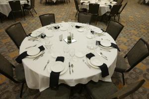 una mesa redonda con platos blancos y vasos. en River Bend Casino & Hotel en Wyandotte