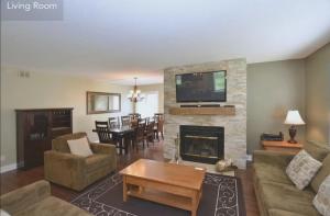 sala de estar con chimenea y TV encima. en Large modern ground floor condo at Mountain Walk, en Blue Mountains