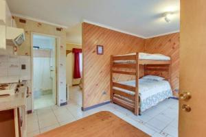 a bedroom with a bunk bed and a bathroom at Apart Hotel Blumenau in Osorno