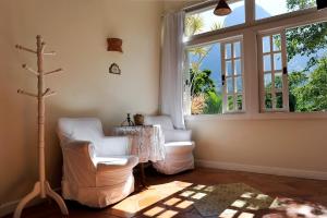 a room with two chairs and a table and a window at Pousada Recanto das Araras in Araras Petropolis