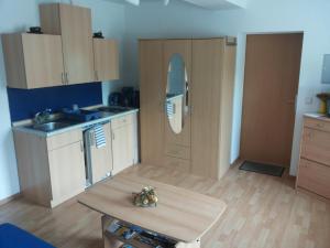 a kitchen with wooden cabinets and a table at hausamsolschacht in Bad Kösen