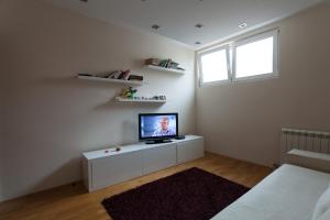 uma sala de estar com televisão num armário branco em Apartment Matoseva em Belgrado