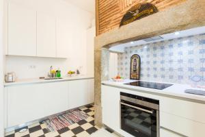 Una cocina con gabinetes blancos y piso a cuadros. en Lisbon Secret & Charming Baixa 4 bedroom apartment, en Lisboa