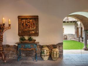 a room with a table and two vases on a wall at Inkaterra La Casona Relais & Chateaux in Cusco