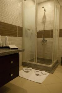 ein Badezimmer mit Dusche und zwei Handtüchern auf dem Boden in der Unterkunft Elite Residence & Aqua Park in Ain Suchna