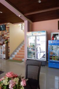 a shop with a drink cooler and a chair at Na Chaidej hotel in Suratthani