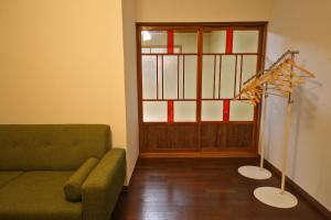 a living room with a green couch and a window at sumica apartments in Nikko