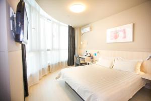 a hotel room with a bed and a window at Jinjiang Inn Datong Pingcheng Bridge in Datong