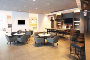 a restaurant with tables and chairs and a bar at Hyatt Place Austin Airport in Austin