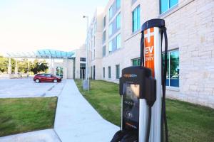 a parking meter on a sidewalk next to a building at Hyatt Place Austin Airport in Austin