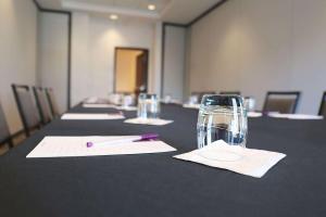 a long table with a pen and a glass at Hyatt Place Austin Airport in Austin