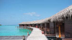 a row of huts on a pier in the water at Filitheyo Island Resort in Filitheyo